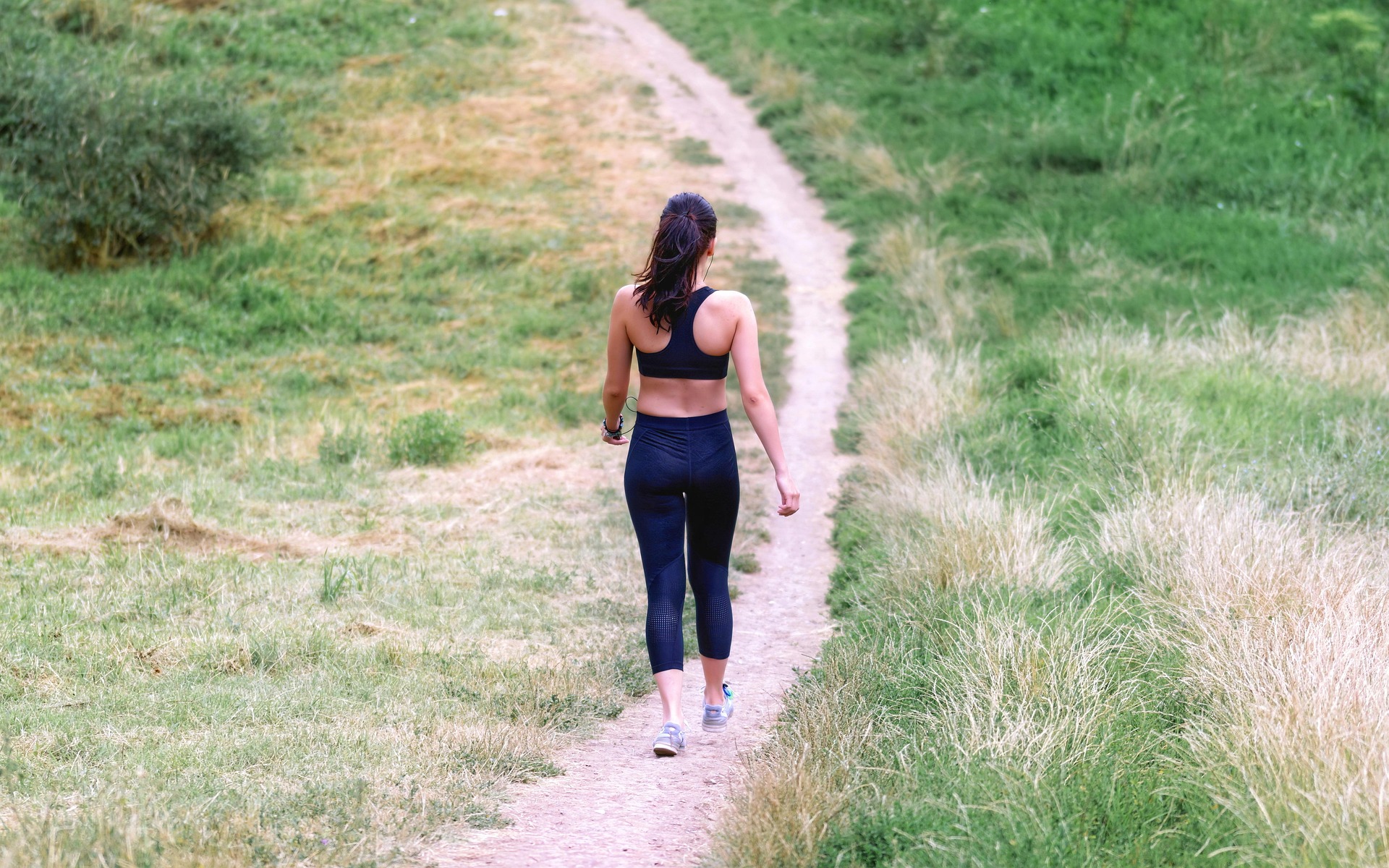 Person walking outdoors tracking steps with a journal