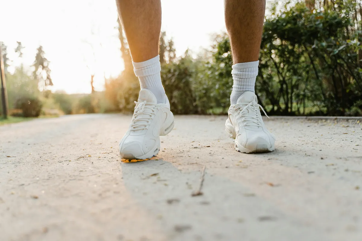 Person walking outdoors tracking a daily step streak on iPhone