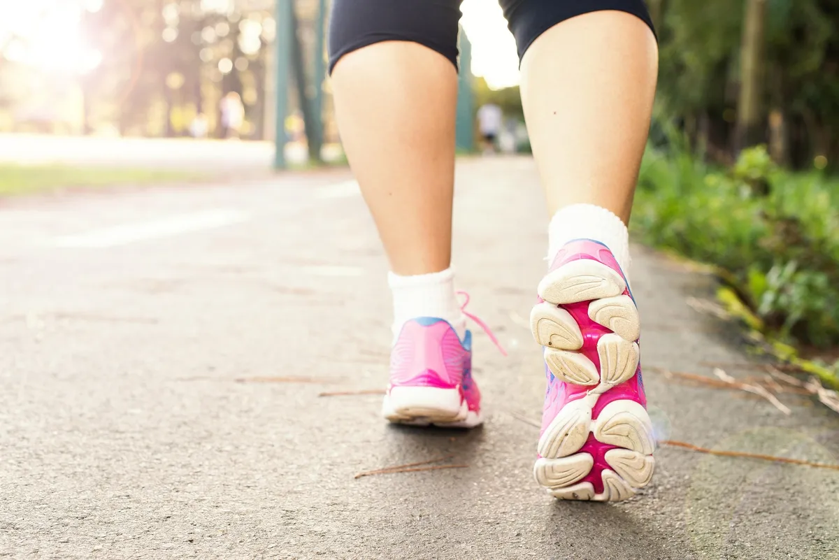 Person walking for fitness and motivation with step tracking app